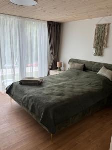a bedroom with a large bed with a green blanket at Seaside apartment x Monciškės in Palanga