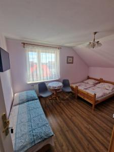 a bedroom with two beds and a table and chairs at Pensjonat Elżbieta in Łeba
