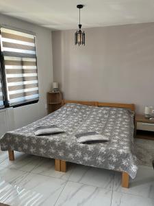 a bed in a white room with a bedspread at Miljaca in Pirot