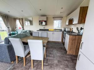 een keuken en woonkamer met een tafel en stoelen bij Caravan In Scratby, Norfolk Ref 50071D in Great Yarmouth +19 foto's