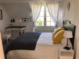 a bedroom with a large bed with a window at Le jardin de Dragey in Dragey