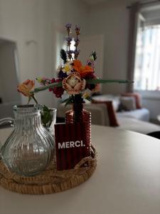 Un jarrón con flores sobre una mesa. en Cozy apartment, en Le Mans