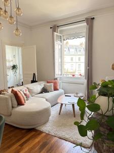 una sala de estar con un sofá y una mesa en Cozy apartment, en Le Mans