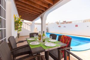 ein Esszimmer mit einem Tisch, Stühlen und einem Pool in der Unterkunft Beautiful 3 Bedroom Holiday Villa in Callao Salvaje