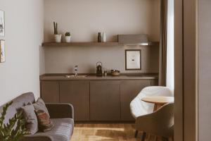 a living room with a couch and a kitchen at Bold Hotel München Giesing in Munich