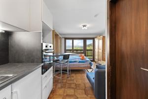 una cucina e un soggiorno con un letto sullo sfondo di Arnica 2 - 2 pers - piscine a Nendaz