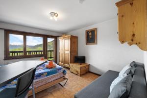 una stanza con un letto, un tavolo e un divano di Arnica 2 - 2 pers - piscine a Nendaz