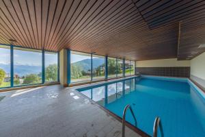 una grande piscina con finestre in un edificio di Arnica 2 - 2 pers - piscine a Nendaz