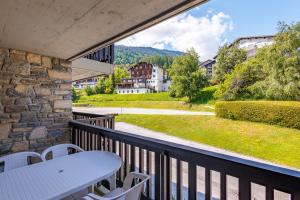 balkon ze stołem i krzesłami oraz widokiem w obiekcie Arnica 15 - 4 pers - piscine w mieście Nendaz