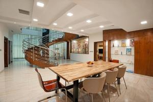 a dining room with a wooden table and chairs at 4 BHK Luxury Penthouse- Sliceinn Velvet, Wilson Garden, Bangalore in Bangalore