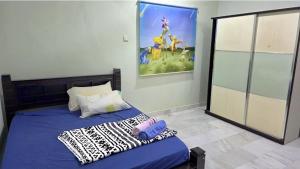 a bedroom with a bed with a painting on the wall at Kuantan Tok Sira Spacious 5 Rooms Bangalow near Teluk Cempedak in Kuantan