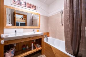 ein Badezimmer mit Waschbecken, Badewanne und Spiegel in der Unterkunft Les Arolles n°G54 in Valloire + 12 Fotos