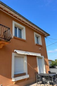 a house with a table and chairs in front of it at Résidence Dalma appartement 6 in Cazaubon