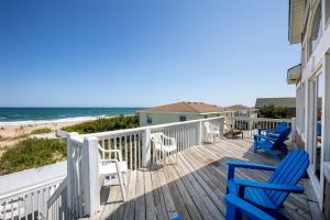 een terras met stoelen en tafels en het strand bij Nags Head Oceanfront Private Beach Access & Pool in Nags Head