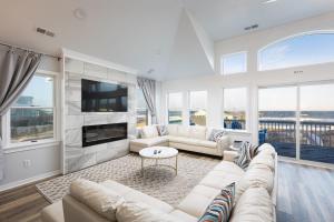 een woonkamer met witte meubels en grote ramen bij Nags Head Oceanfront Private Beach Access & Pool in Nags Head