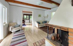 a living room with a fireplace and a couch at 2 Bedroom Nice Home In Munka-Ljungby in Munka-Ljungby