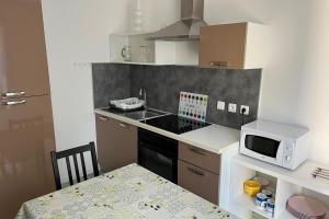 a small kitchen with a table and a microwave at Résidence Dalma appartement 1 in Cazaubon
