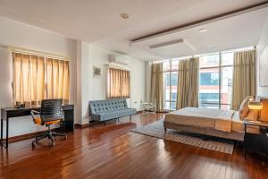 a bedroom with a bed and a desk and a couch at 4 BHK Luxury Penthouse- Sliceinn Velvet, Wilson Garden, Bangalore in Bangalore +30 photos