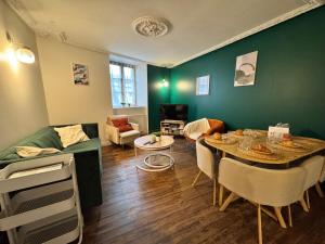 a living room with a table and a green wall at La Maison D'Oscar in Parthenay +31 photos