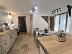 a kitchen with a table and a dining room at Maison Etona in Esparron-de-Verdon +20 photos