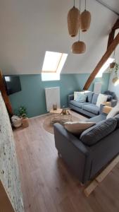 a living room with a couch and a tv at Spring Lodge - La grange aux quatres saisons - Pairi Daiza in Brugelette
