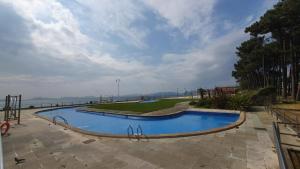 a swimming pool in a park next to the ocean at apartamento Vigo Samil in Vigo