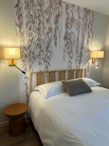 a bedroom with a large white bed with a table at La remise d'Edouard in Saint-Papoul