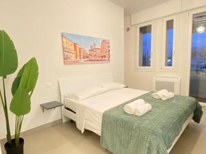 a bedroom with two beds and a potted plant at Suite Emilia 1 in Bologna