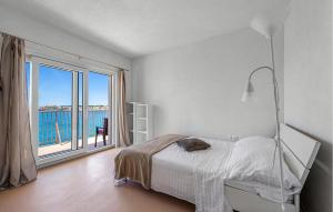 a white bedroom with a bed and a large window at Stunning Apartment In Brodarica in Brodarica