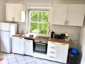 a kitchen with white cabinets and a sink and a window at Monteurzimmer am Bahnhof Biesenthal - 3 große Apartments in Biesenthal