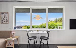 a dining room with a table and two windows at 3 Bedroom Amazing Home In Fur in Fur