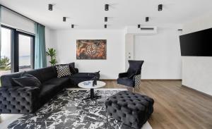 salon z czarną skórzaną kanapą i stołem w obiekcie NEW! Villa El Capitano Private Seaview Retreat Near Split w Podstranie