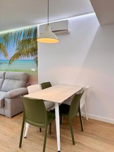a dining room with a table and green chairs at Color Suites Alicante in Alicante +33 photos