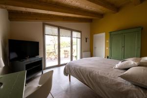 una camera con letto, TV e patio di Agriturismo Glamping Pettirosso a Fratta Terme