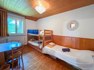 a room with two beds and a table and a table at Villars - Charme et panorama in Ollon