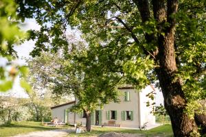 una casa con un albero di fronte di Agriturismo Glamping Pettirosso a Fratta Terme