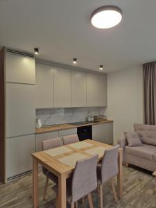 kuchnia i jadalnia ze stołem i krzesłami w obiekcie Brickstone Apartments Mabork w mieście Malbork