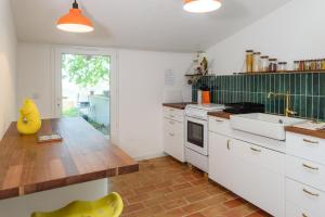 a kitchen with white cabinets and a wooden counter top at Dépendance d'un mas provençal in Solliès-Pont