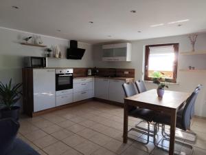 a kitchen with a wooden table and a table and chairs at Ferienwohnung Obsthof Lutz - nur Urlaubsgäste in Fisch