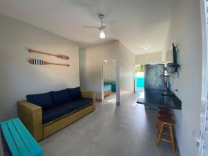a living room with a blue couch and a table at Chalés Céu e Mar Ubatuba in Ubatuba
