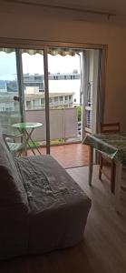 Un dormitorio con una cama y vista a un balcón. en Studio cosy avec vue exceptionnelle sur l'étang de Thau, en Balaruc-les-Bains