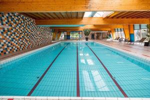 a large swimming pool in a large building at BLUE BEACH HOUSE in Breskens