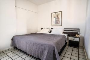 a bedroom with a bed with a purple blanket at Flat c/ Limpeza Diária | Piscina e Praia - DL1804 in Recife +116 photos