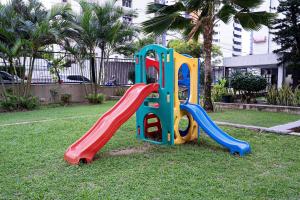 a playground with a slide in the grass at Flat c/ Limpeza Diária | Piscina e Praia - DL1804 in Recife