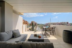a living room with a couch and a table on a balcony at Ribera del Marlin IX Sotogrande in Sotogrande