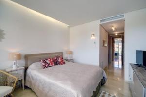 a bedroom with a bed with a red pillow on it at Ribera del Marlin IX Sotogrande in Sotogrande +9 photos