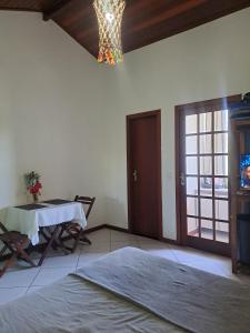 a room with a table and a chandelier at Bora Bora Geribá Kitnet in Búzios