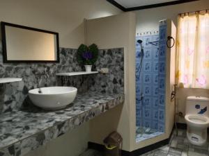 a bathroom with a sink and a toilet at Binalbagan Staycation in Sampong