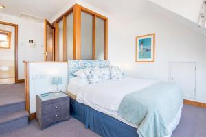 ein Schlafzimmer mit großem Bett und Treppe in der Unterkunft 5 Mariners Reach in Saundersfoot