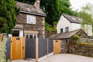 a house with a wooden fence in front of it at Ferry View Studio with Hot Tub and Parking in Bowness-on-Windermere
